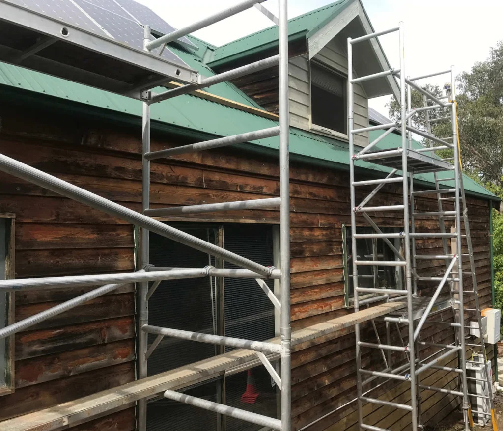 Eastend Painting crew working from scaffolding on a timber-clad gable