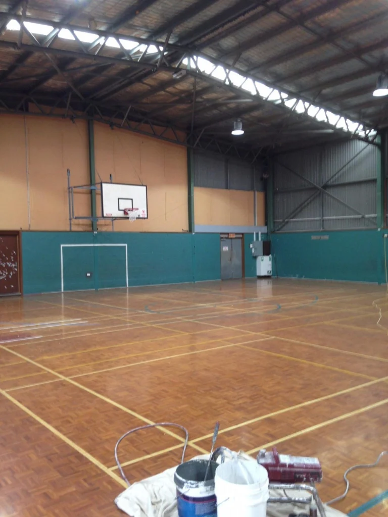 Painter working in an indoor sports hall